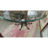 A wrought iron based table with glass top.
