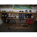 A wooden shoe rack and quantity of ladies shoes.
