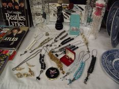 A quantity of costume jewellery bead necklaces, Tiffany earrings (boxed) and figure stands etc.