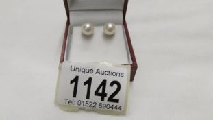 A pair of cultured pearl large stud earrings.