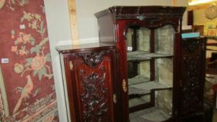 An ornate ebonised display cabinet.