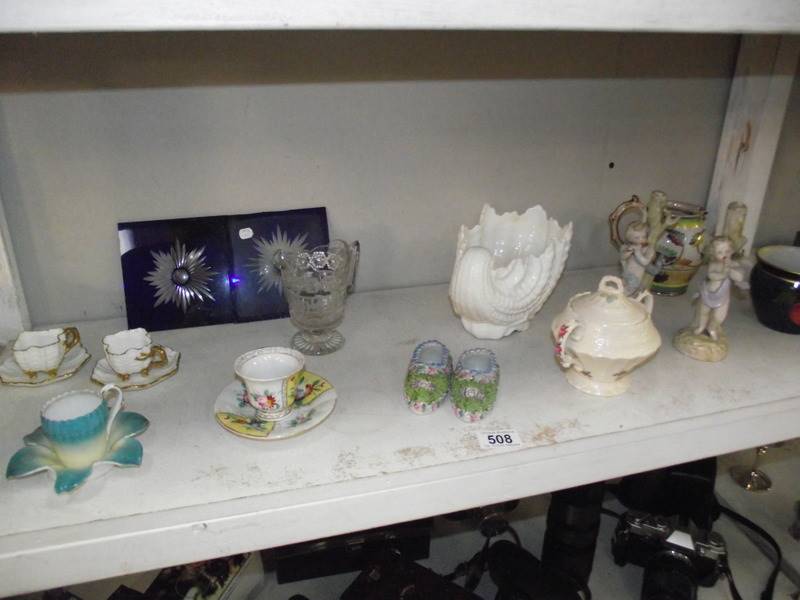 A mixed lot including cherub figures some a/f. Tea cups and saucers etc.