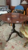 A mahogany inlaid tripod table.