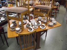 A teak drop leaf table with 4 chairs.