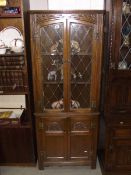 An oak corner cupboard with leaded glass panels