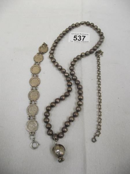 A George V silver threepenny bit bracelet, a necklace and another bracelet.