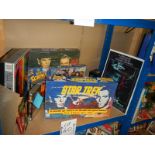 A large shelf of Star Trek collectables including Jigsaw puzzles, VHS, diecast etc.