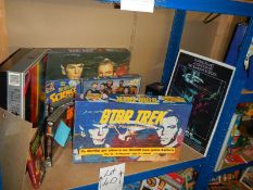 A large shelf of Star Trek collectables including Jigsaw puzzles, VHS, diecast etc.