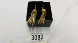 A pair of vintage yellow metal tassle earrings with gold shepherds hook fittings.
