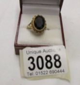 An almandine garnet gem set ring in an oval shape in 9ct gold, size O.