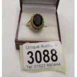 An almandine garnet gem set ring in an oval shape in 9ct gold, size O.