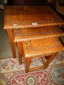 A carved oak nest of tables.