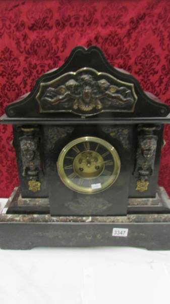 A Victorian black marble mantle clock with ormolu mounts.