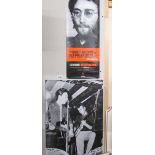 A John Lennon poster and one other.