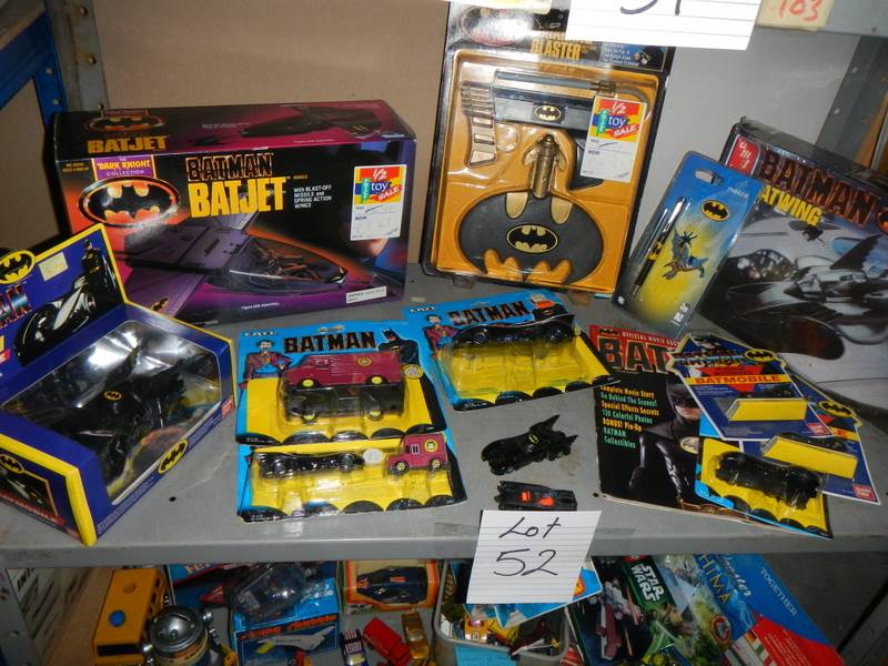 A shelf of assorted Batman toys including Batjet etc.