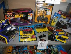 A shelf of assorted Batman toys including Batjet etc.