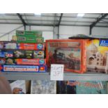 A top shelf of jigsaw puzzles including 3D.