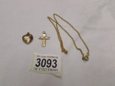 A yellow metal locket, cross and chain.