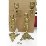 Two brass cherub candlesticks.