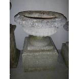 A large heavy garden urn on stand.