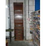 A tall and slim mahogany bookcase.