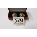 A pair of silver 'Versace' style lion mask cuff links with ruby eyes.