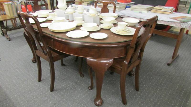A good quality oval wind out dining table with four chairs.
