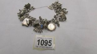 A silver charm bracelet with 20 silver and white metal charms.