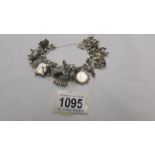 A silver charm bracelet with 20 silver and white metal charms.