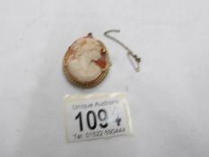 A vintage shell cameo brooch of female profile with safety chain,