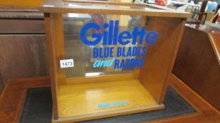 A glazed cabinet bearing Gillette Blue Blades & Razors, Made in USA signage.