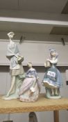 A Lladro tall girl with basket, A Lladro girl with flowers and a Lladro lady with parasol.