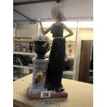 An art deco style figure of a lady by pedestal