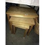 A nest of three pine tables