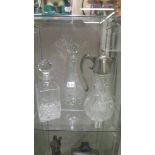 A cut glass claret jug and 2 cut glass decanters.