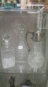 A cut glass claret jug and 2 cut glass decanters.