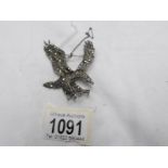 A vintage silver marcasite eagle brooch with safety chain.