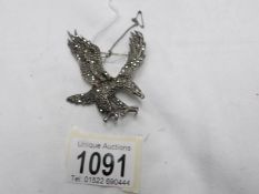 A vintage silver marcasite eagle brooch with safety chain.