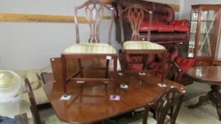 A mahogany extending dining table with one extra leaf and a set of 6 dining chairs.
