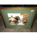 A framed and glazed picture of a village scene