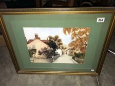 A framed and glazed picture of a village scene