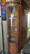 A tall corner display cabinet bearing Rolex Wrist watches signage.