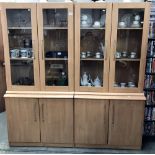 A pair of beech effect glazed top cupboards