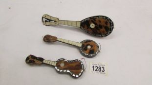 3 tortoise shell inlaid musical instruments, mandolin, guitar and banjo.