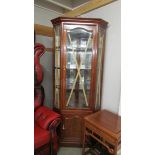 A tall mahogany corner cabinet.