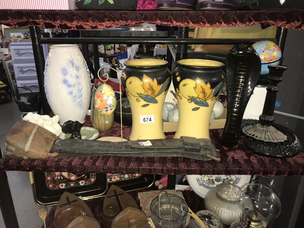 A shelf of interesting items including cow bell and vases