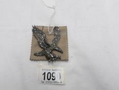 A vintage silver marcasite eagle brooch with safety chain.