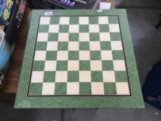 A green and white chess board (measures 20 cm x 20 cm).