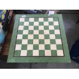 A green and white chess board (measures 20 cm x 20 cm).