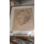 A framed and glazed pastel portrait of a young child.
